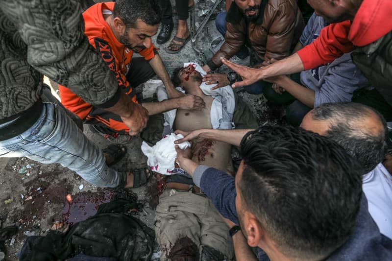 Palestinians try to revive an injured person lying on the ground after an Israeli air strike. Abed Rahim Khatib/dpa