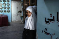 An Afghan girl looks out at Tajrobawai Girls High School, in Herat, Afghanistan, Thursday, Nov. 25, 2021. While most high school girls in Afghanistan are forbidden to attend class by the country's Taliban rulers, one major exception are those in the western province of Herat. For weeks, girls there have been attending high school classes, thanks to a unique effort by teachers and parents to persuade local Taliban administrators to allow schools to reopen. (AP Photo/Petros Giannakouris)