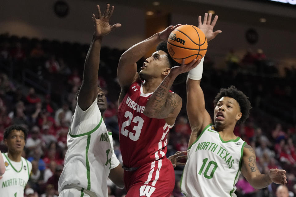 Wisconsin's Chucky Hepburn (23) shoots around North Texas' Moulaye Sissoko, left, and North Texas' Kai Huntsberry (10) during the second half of an NCAA college basketball game in the semifinals of the NIT, Tuesday, March 28, 2023, in Las Vegas. (AP Photo/John Locher)