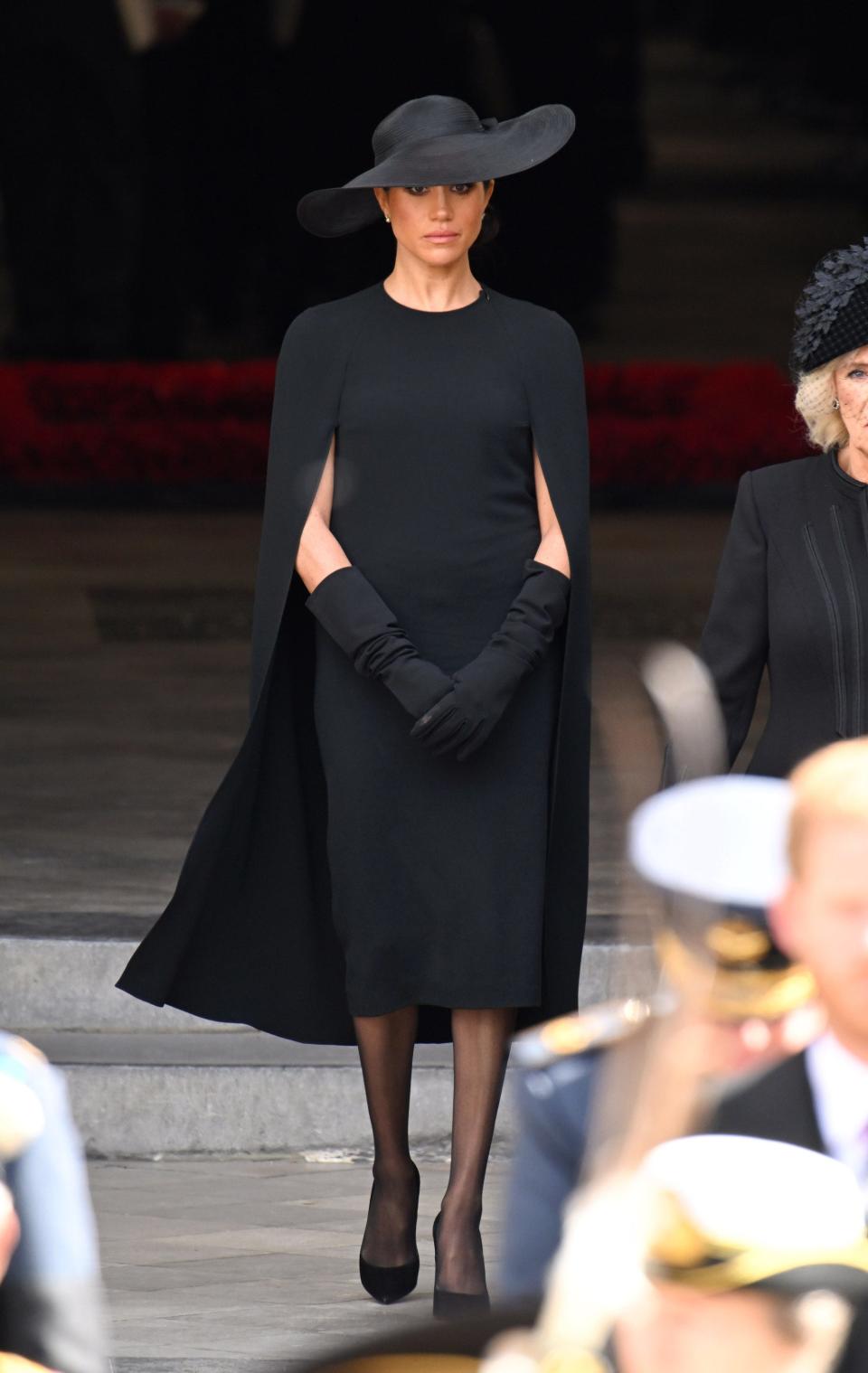 Meghan Markle walks in a black dress at Queen Elizabeth II's funeral.