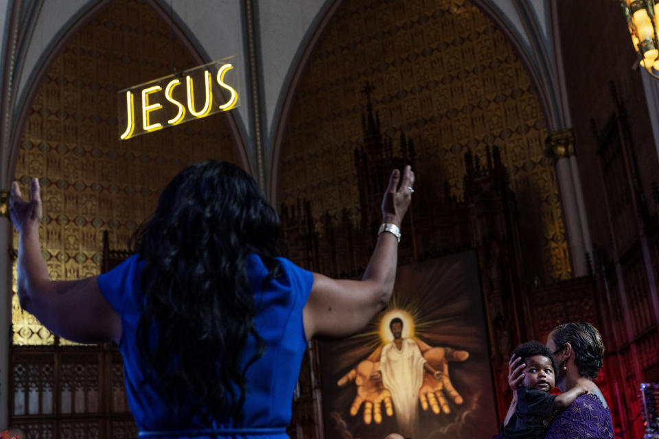 Jenny Edwards, right, holds her eight-month-old grandson, Daniel, during a church service at St. Sabina Catholic Church in the Auburn Gresham neighborhood in Chicago, Sunday, Aug. 23, 2020. In harrowing moments, in the sobs of grieving mourners and the incessant wail of sirens, the crises of 2020 have played out painfully within this single Chicago community. (AP Photo/David Goldman)