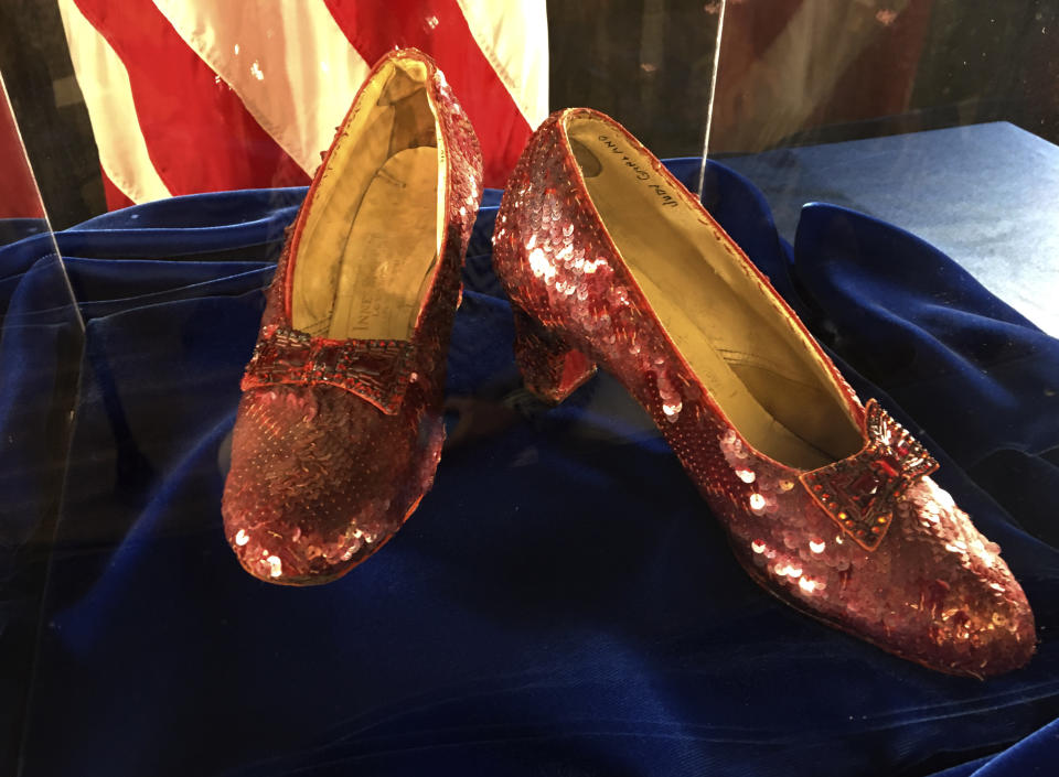 A pair of ruby slippers once worn by actress Judy Garland in the "The Wizard of Oz" are displayed at a news conference Tuesday, Sept. 4, 2018, at the FBI office in Brooklyn Center, Minn. Authorities announced that the slippers, stolen in 2005 from the Judy Garland Museum in Grand Rapids, Minn., were recovered in a sting operation. The FBI says it has multiple suspects in the extortion and that the investigation continues. Four pairs of ruby slippers worn by Garland in the movie are known to exist. Judy Garland's name can be seen in the shoe at right. (AP Photo/Jeff Baenen)