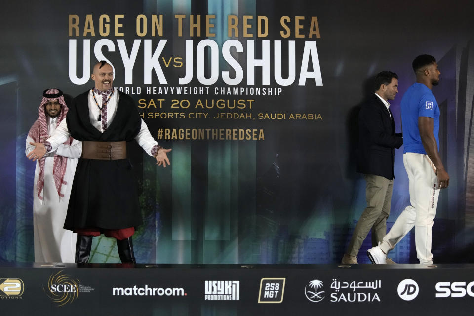 Ukraine's Oleksandr Usyk, left, gestures and Britain's Anthony Joshua, right, pose head-to-head for the media after their press conference in Jeddah, Saudi Arabia, Wednesday, Aug. 17, 2022. Joshua is due to fight defending champion Usyk in a heavyweight boxing rematch in Jeddah on Aug. 20. (AP Photo/Hassan Ammar)