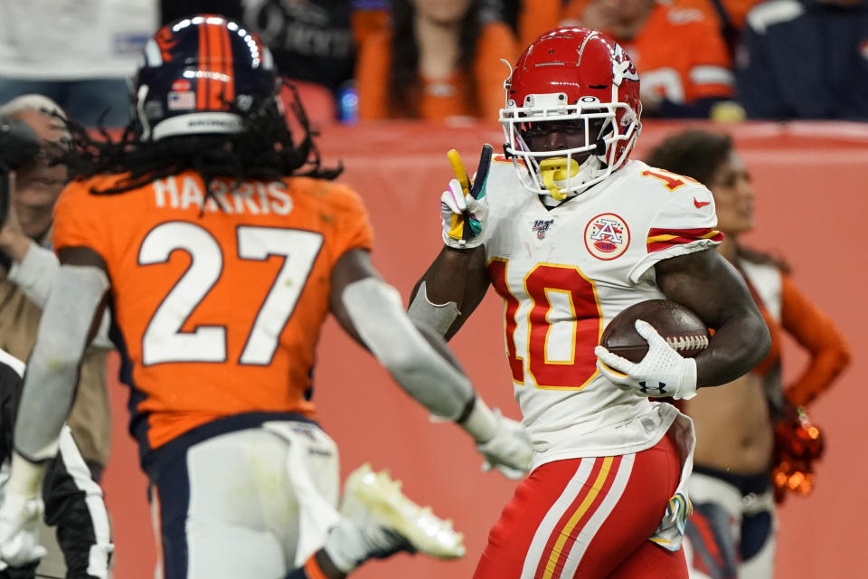 Kansas City Chiefs wide receiver Tyreek Hill (10) signals to Denver Broncos cornerback Davontae Harris (27) as he scores a touchdown during the second half of an NFL football game, Thursday, Oct. 17, 2019, in Denver. (AP Photo/Jack Dempsey)