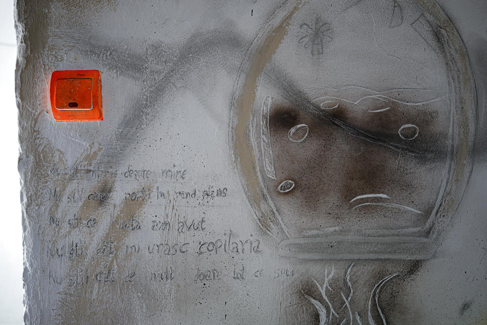 In this photo taken on Sunday, Dec. 15, 2019, a drawing and text scribbled by a resident decorate a room wall in a transit home ran by Florin Catanescu, in Brasov, Romania. Thirty years after the 1989 death of Romania's communist-era dictator, the country is still grappling with the ugly legacy of its once-horrific orphanages. Now some of those who grew up abused and unloved in those failed institutions are turning their trauma into commitment. Florin Catanescu, who lived in an orphanage until 1997, now runs a transition home helping those leaving state care to have a better chance of leading meaningful lives. . Text reads "You know nothing about me, you don't know how many nights I cried, you know nothing of the life I had, you don't know how much I hate my childhood, and how much everything you say hurts me". (AP Photo/Vadim Ghirda)