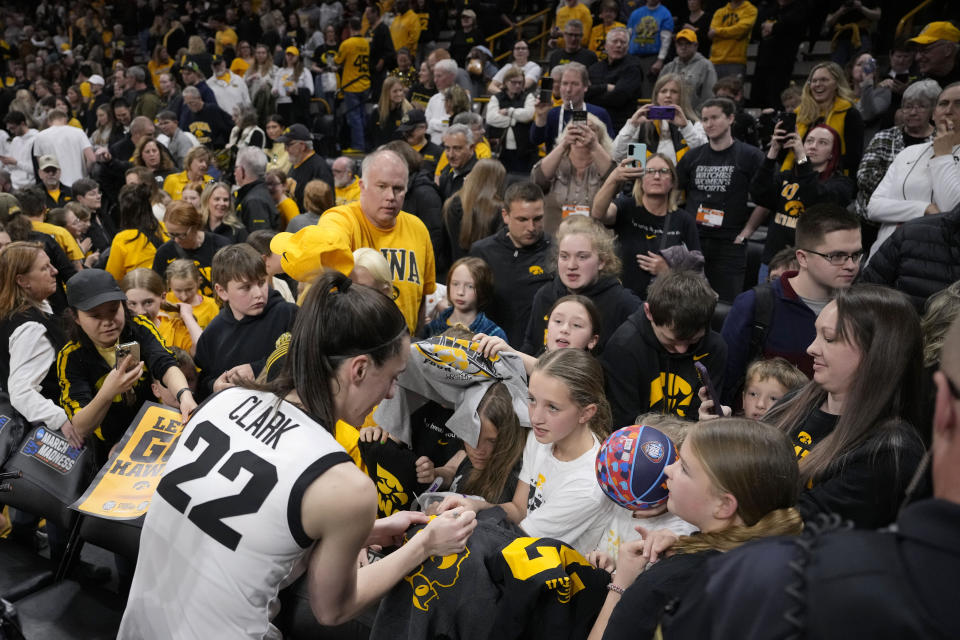 Iowa guard Caitlin Clark (22) signs autographs for fans following their 91-65 victory over Holy Cross in a first-round college basketball game in the NCAA Tournament, Saturday, March 23, 2024, in Iowa City, Iowa. (AP Photo/Matthew Putney)