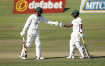 Zimbabwean batsmen Brendan Taylor,left and Regis Chakabva touch gloves during the second test cricket match against Pakistan at Harare Sports Club, Sunday, May, 9, 2021.(AP Photo/Tsvangirayi Mukwazhi)