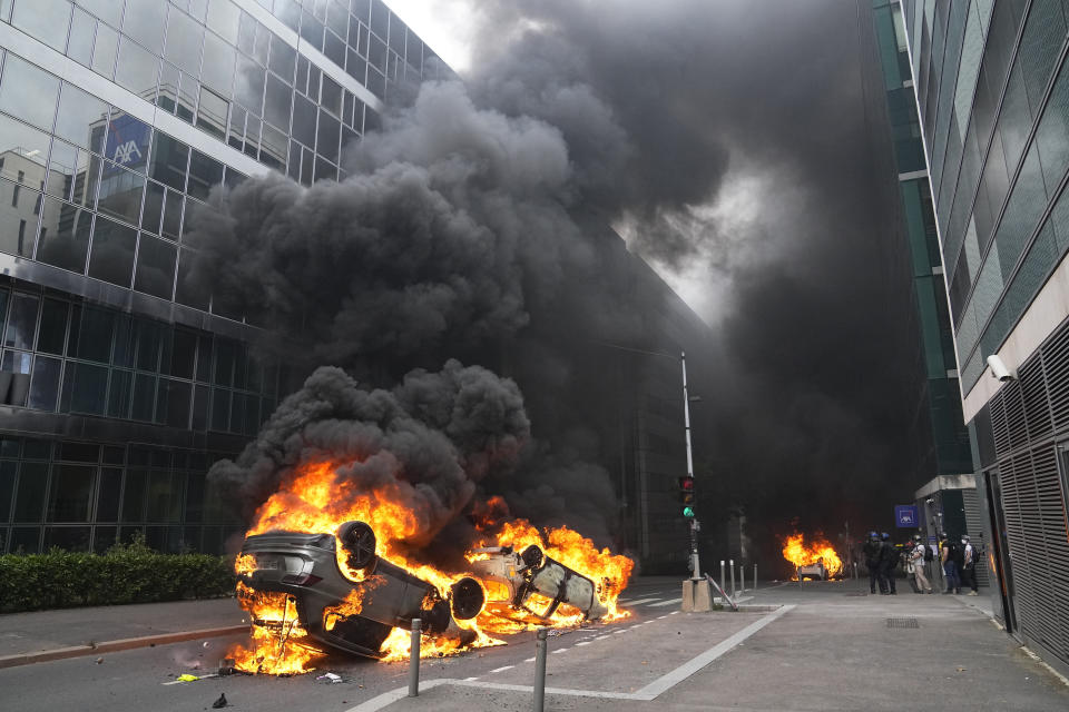 FILE - Cars burn after a march for Nahel, Thursday, June 29, 2023 in Nanterre, outside Paris. The killing of 17-year-old Nahel during a traffic check Tuesday, captured on video, shocked the country and stirred up long-simmering tensions between young people and police in housing projects and other disadvantaged neighborhoods around France. After more than 3,400 arrests and signs that the violence is now abating, France is once again facing a reckoning (AP Photo/Michel Euler, File)