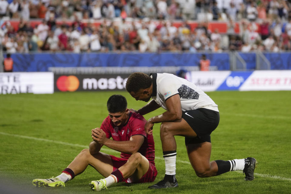Fiji's Teti Tela, right, comforts Georgia's Luka Matkava at the end of the Rugby World Cup Pool C match between Fiji and Georgia at the Stade de Bordeaux in Bordeaux, France, Saturday, Sept. 30, 2023. (AP Photo/Thibault Camus)