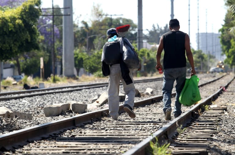 Central American migrants walk along the train lines in Mexico preparing to jump on "The Beast," a train that will take them to the border with the United States