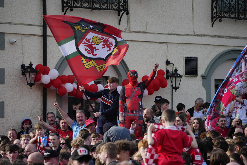 Supporters of the Wrexham FC soccer team celebrate their promotion to the Football League in Wrexham, Wales, Tuesday, May 2, 2023. (AP Photo/Jon Super)