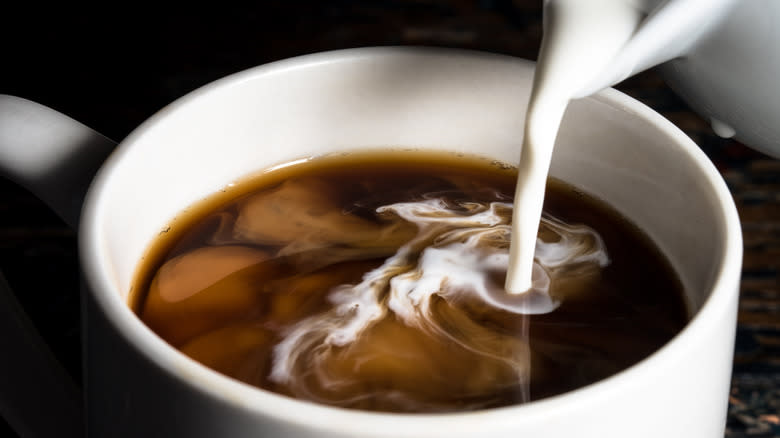 Pouring cream in coffee