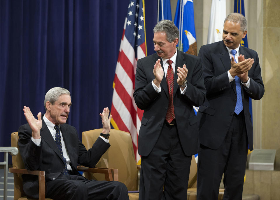 <p>Attorney General Eric Holder, right, and Deputy Attorney General James Cole, center, applaud outgoing FBI Director Robert Mueller during a farewell ceremony at the Justice Department in Washington, Thursday, Aug. 1, 2013. Mueller is stepping down in September after 12 years heading the agency (Photo: Evan Vucci/AP) </p>