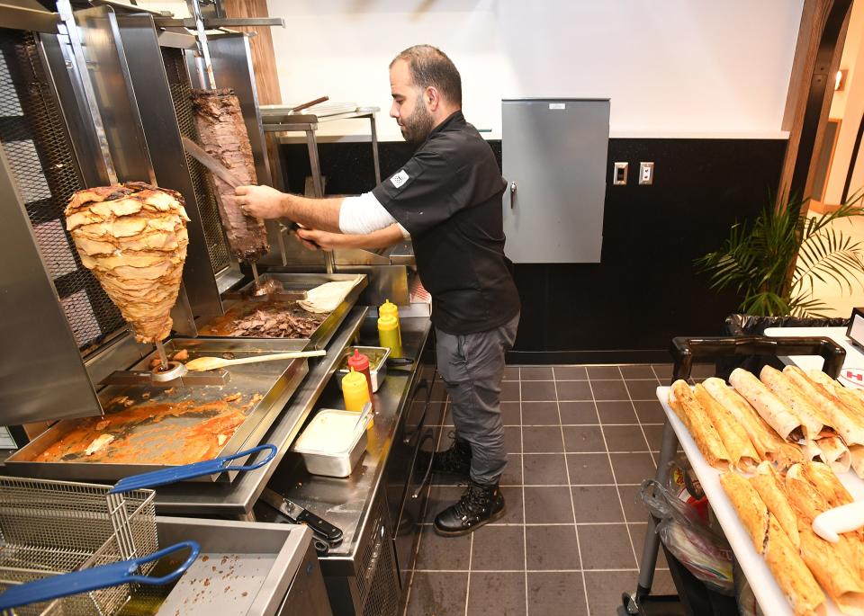 At the Shawarma Station vendor stall, Mohamed Khir Al Jallad cuts beef for shawarmas during a VIP event, held Thursday, at the Flagship City Food Hall in downtown Erie. The newly renovated space with nine food vendors was set to open to the public on Monday.