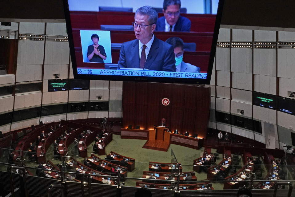 A screen shows Hong Kong's Financial Secretary Paul Chan delivers his annual budget speech at the Legislative Council in Hong Kong Wednesday, Feb. 26, 2020. Hong Kong's government is proposing a nearly $1,300 cash handout for each resident over 18 years old to help alleviate hardships brought on by the spreading viral outbreak and prolonged political protests.(AP Photo/Vincent Yu)