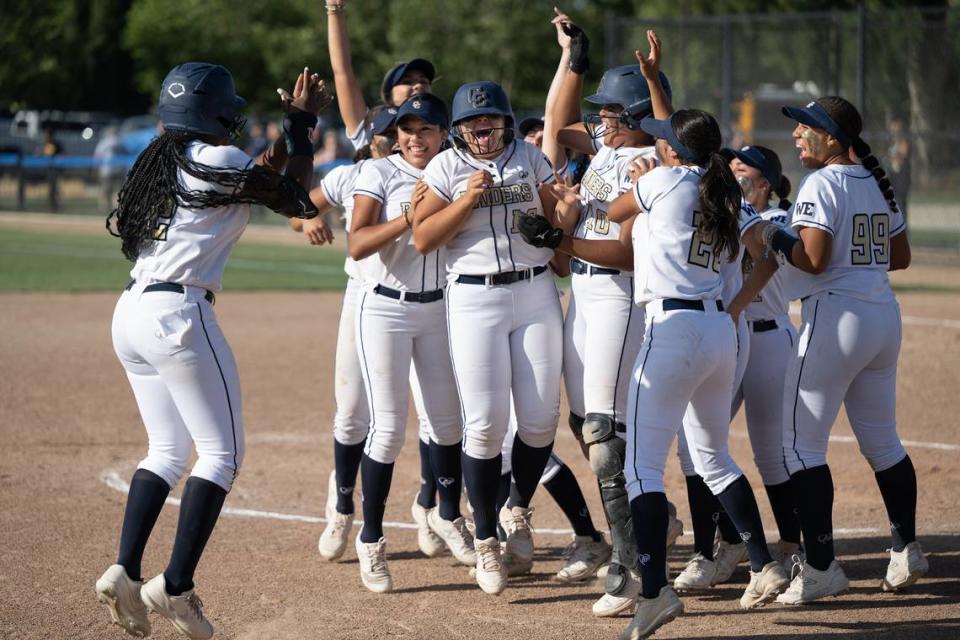 Teammates mob Central Catholic’s Jazzelyn Rios after she doubled in the winning run in the seventh inning during the Sac-Joaquin Section Division III semifinal game with Oakdale at Central Catholic High School in Modesto, Calif., Tuesday, May 23, 2023.