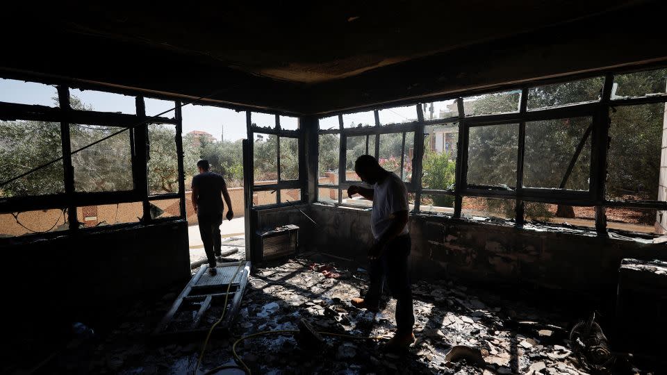 Palestinian men check on a burned building after an attack by Israeli settlers, near Ramallah, in the Israeli-occupied West Bank, on June 21, 2023. - Mohamad Torokman/Reuters