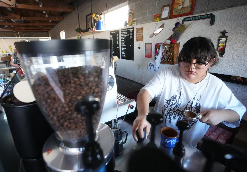 Jordan Manuelito, a collective member at Skoden Coffee & Tea works behind the bar at the Uptown Phoenix café.