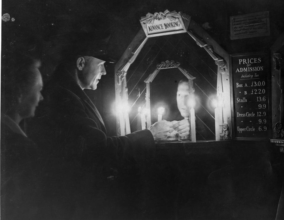 People buy tickets at a candle-lit box office during a power outage in 1947.