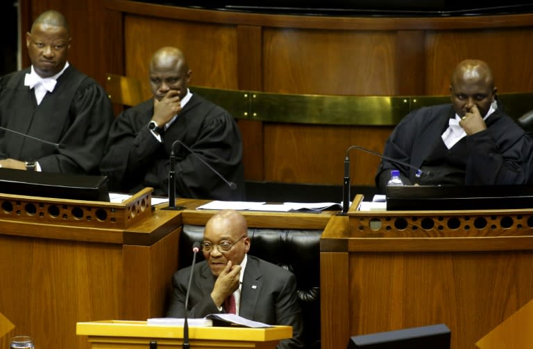 South African President Jacob Zuma sits down as he is interrupted trying to give his state of the nation address in Cape Town, South Africa on February 11, 2016