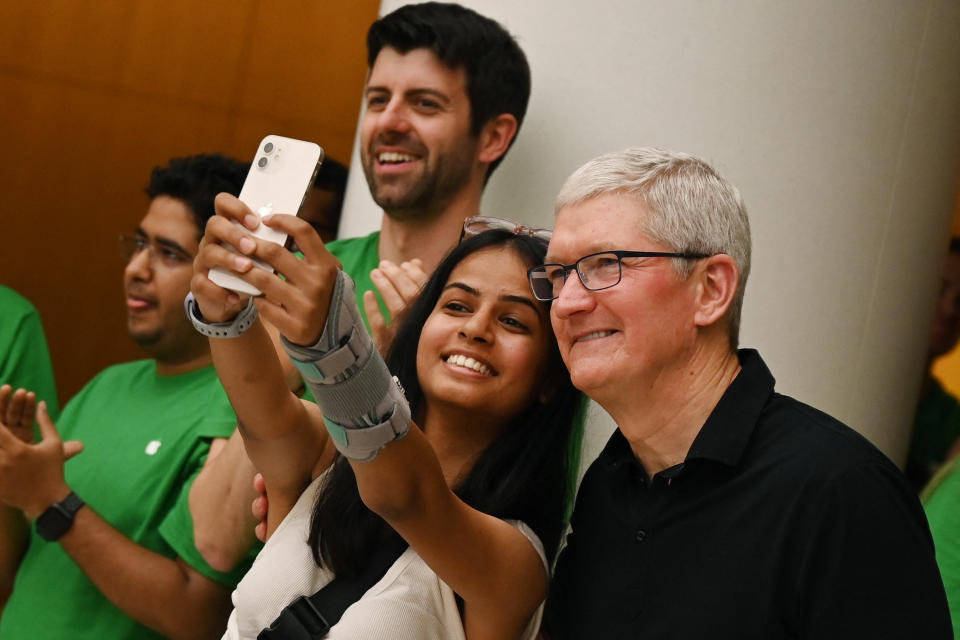 Apple CEO Tim Cook poses for a selfie with a woman during the opening of New Delhi&#39;s first Apple retail store at a mall in New Delhi on April 20, 2023. (Photo by Arun SANKAR/AFP)