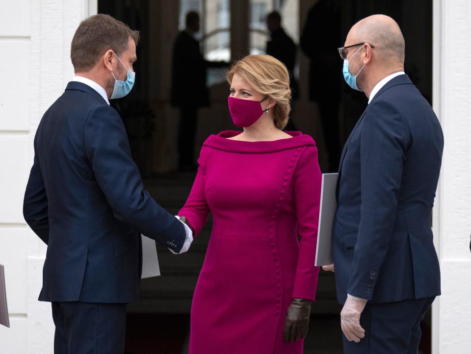 Newly appointed Slovak Prime Minister Igor Matovic (L), leader of the OLaNO anti-graft party shakes hands with President Zuzana Caputova after a swearing in ceremony of the new four-party coalition government and before a family picture on March 21, 2020 outside of the Presidential palace in Bratislava. - The ceremony was held without members of the press and all appointed government members wore gloves and face mask to prevent the spread of novel coronavirus. (Photo by JOE KLAMAR / AFP) (Photo by JOE KLAMAR/AFP via Getty Images)