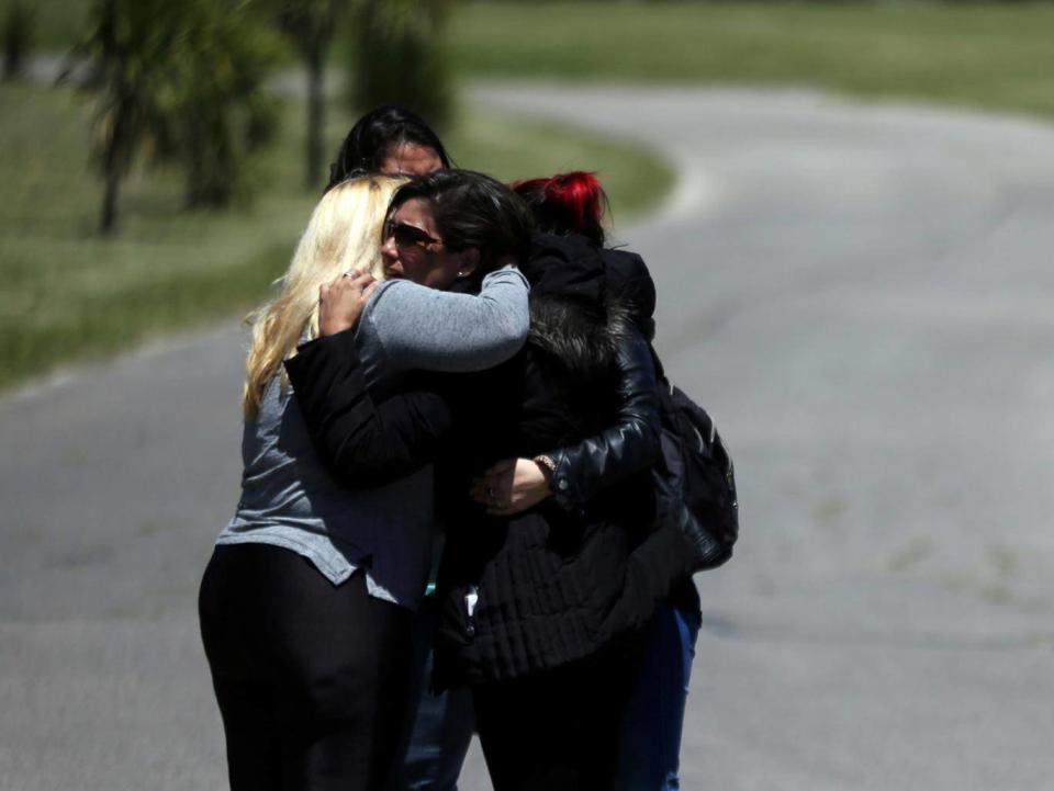 Relatives comfort each other (Reuters)