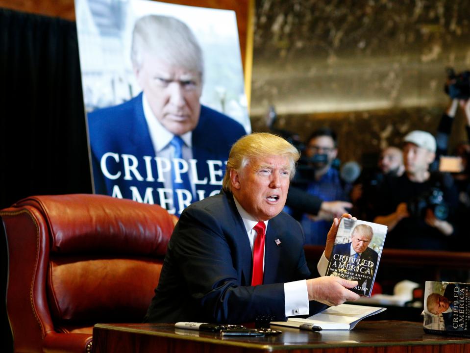 Donald Trump signs copies of his 2015 book, Crippled America (EPA)