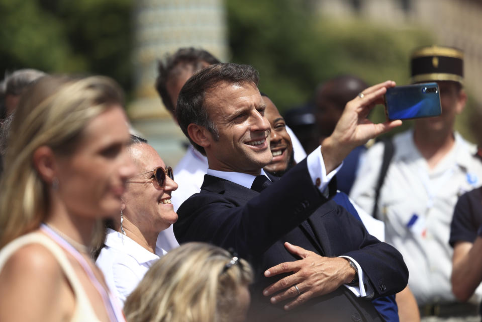 French President Emmanuel Macronmakes a selfie with guests aftere the Bastille Day military parade Friday, July 14, 2023 in Paris. India is the guest of honor at this year's Bastille Day parade, with Prime Minister Narendra Modi in the presidential tribune alongside French President Emmanuel Macron. (AP Photo/Aurelien Morissard, Pool)