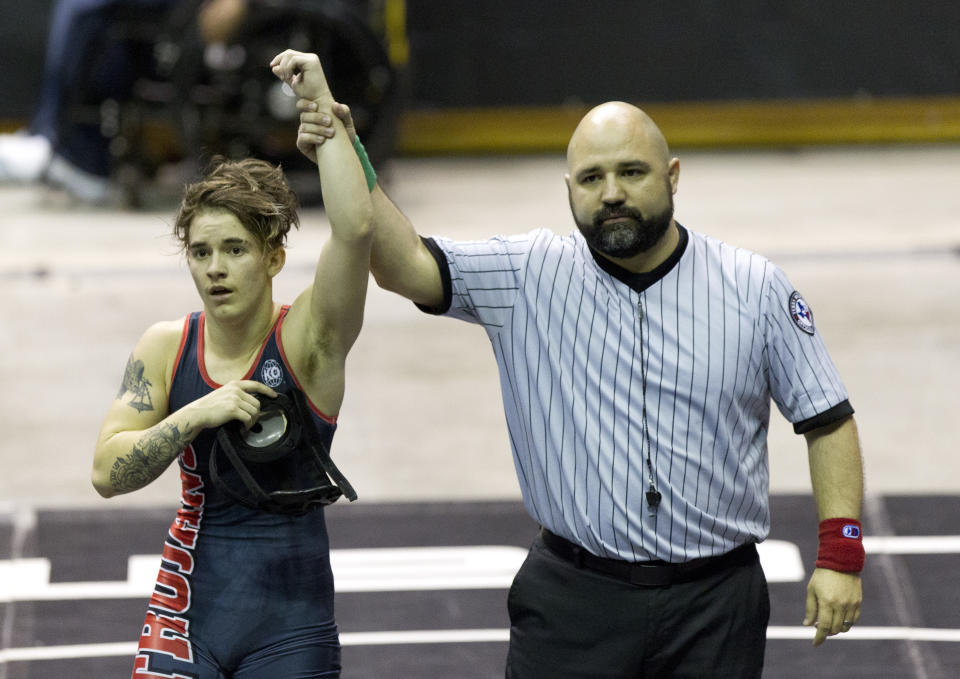 FILE - In this Saturday, Feb. 24, 2018 file photo, a referee raises the arm of Mack Beggs of Euless Trinity after he defeated Chelsea Sanchez of Morton Ranch to defend the Class 6A girls 110-pound title during the UIL State Wrestling Championships at the Berry Center in Cypress, Texas. Texas limits transgender athletes to teams conforming with the gender on their birth certificate. That law came under criticism in 2017 and 2018, when transgender male Beggs won state titles in girls’ wrestling competitions after he was told he could not compete as a boy. (Jason Fochtman/Houston Chronicle via AP)