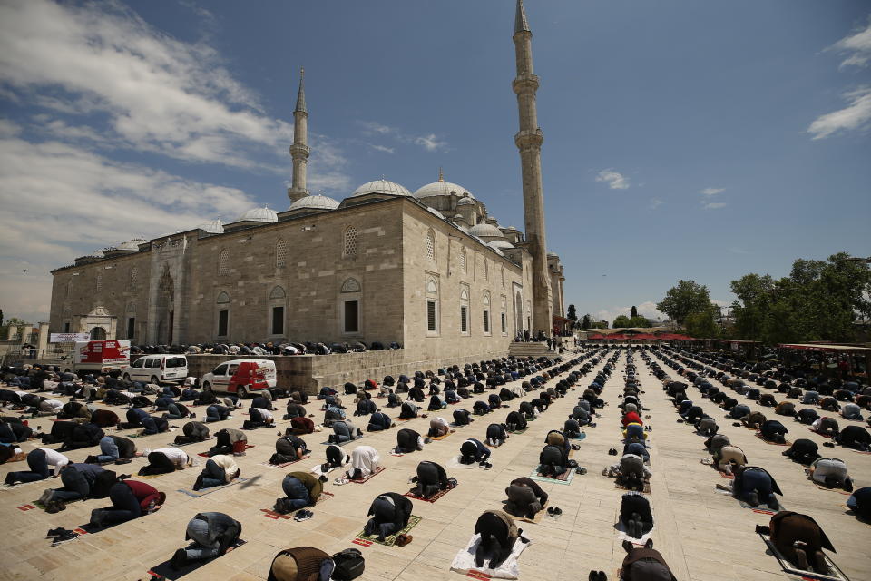 People, wearing face masks and observing social distancing guidelines to protect against coronavirus, attend Friday prayers, outside Fatih mosque, in Istanbul, Friday, May 29, 2020. Worshippers in Turkey have held their first communal Friday prayers in 74 days after the government re-opened some mosques as part of its plans to relax measures in place to fight the coronavirus outbreak. Prayers were held in the courtyards of a select number of mosques on Friday, to minimize the risk of infection. (AP Photo/Emrah Gurel)