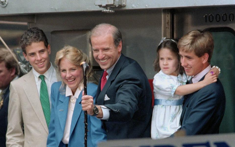 Sen. Joseph Biden of Delaware smiles as he grabs a walking stick presented him for the campaign by a supporter as he leaves aboard a train for Washington after announcing for President  - Bettmann