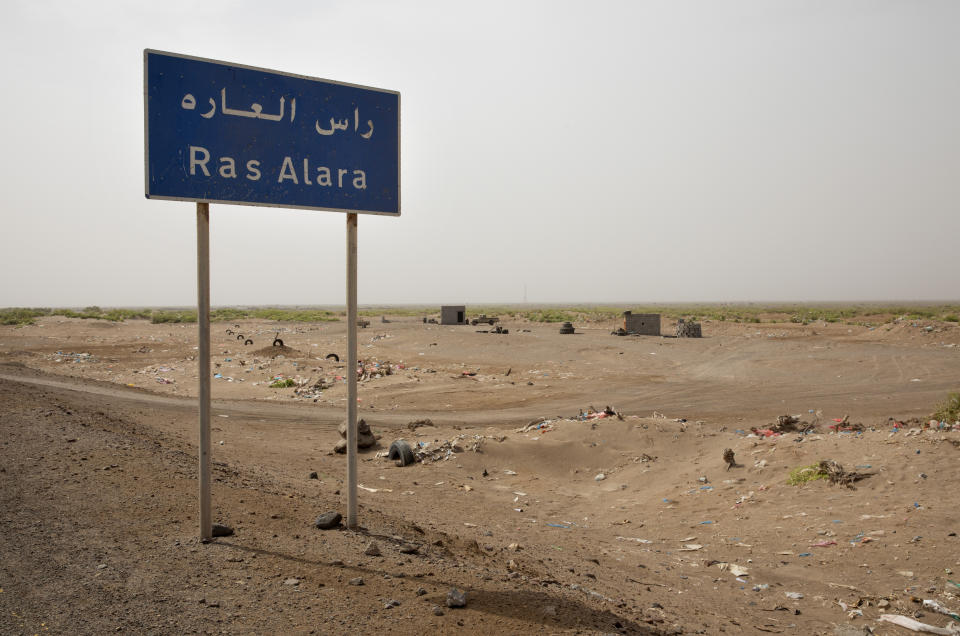 This July 19, 2019 photo shows a road sign leading to the coastal village of Ras al-Ara, Lahj, Yemen. With its systematic torture, Ras al-Ara is a particular hell on the arduous, 900-mile (1,400 kilometer) journey from the Horn of Africa to oil-rich Saudi Arabia. (AP Photo/Nariman El-Mofty)