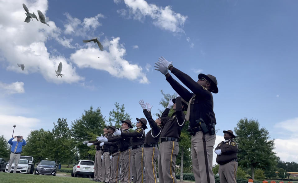 FILE - Sheriff's deputies release white doves for the young victims of a fatal car crash outside a church where the public memorial service was held Thursday, July 15, 2021, in Auburn, Ala. A crash that killed 10 people — including nine children — on a rain-slicked Alabama interstate happened after a tractor-trailer truck slammed into vehicles that had slowed down because of minor crashes, according to a preliminary report released Tuesday, Aug. 3, 2021. (AP Photo/Kim Chandler)