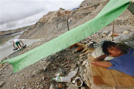 Kyaw Myo Aung, a 17-year-old hand-picker, rests in his tent at a jade mine in Hpakant township, Kachin State July 7, 2013. REUTERS/Minzayar