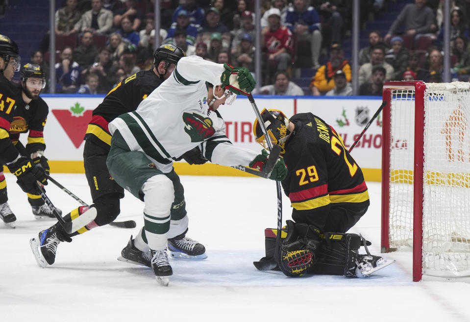 Vancouver Canucks goalie Casey DeSmith, right, stops Minnesota Wild's Joel Eriksson Ek during the first period of an NHL hockey game Thursday, Dec. 7, 2023, in Vancouver, British Columbia. (Darryl Dyck/The Canadian Press via AP)