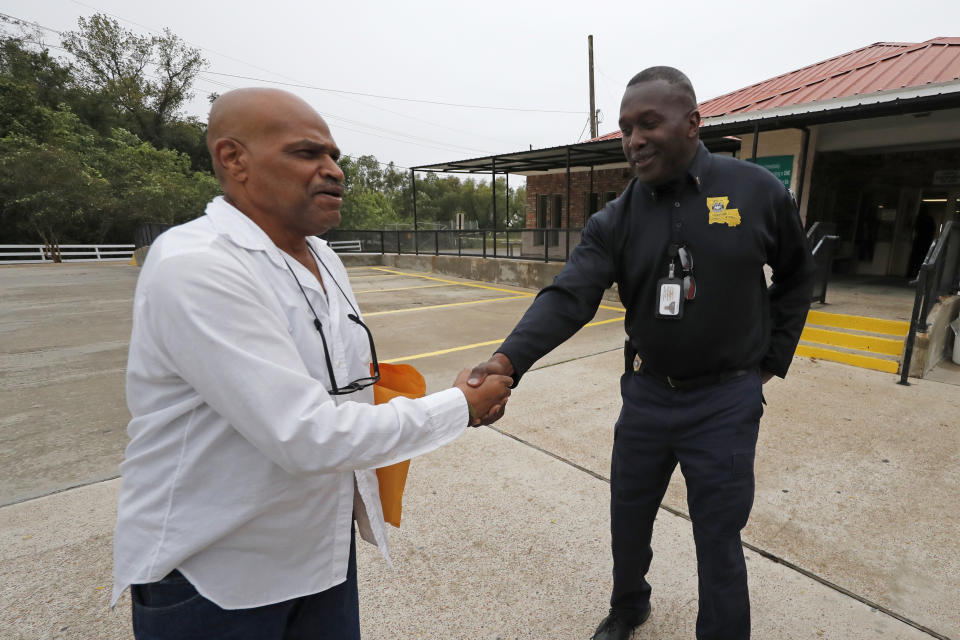 Elvis Brooks shakes hands with a corrections officer after walking out of the Louisiana State Penitentiary at Angola in Angola, La., Wednesday, Oct. 16, 2019. Brooks, who has spent two-thirds of his life in prison for a killing he always denied committing, pleaded guilty to manslaughter and was released. Since his arrest in 1977, Brooks has maintained that he's innocent. Innocence Project New Orleans attorneys say evidence that would have cleared him was withheld at trial. Prosecutors offered the plea agreement Tuesday which was accepted. (AP Photo/Gerald Herbert)