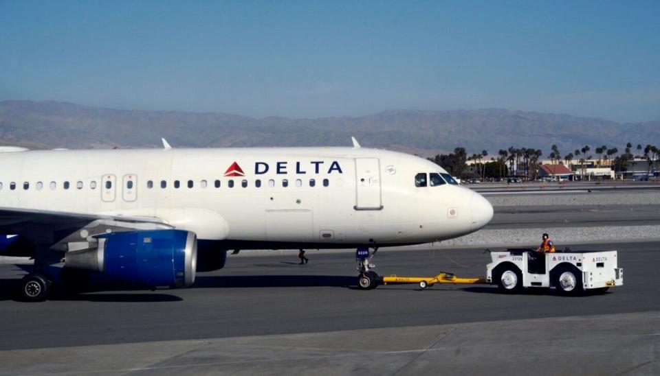 Un miembro del equipo de tierra de Delta Air Lines arrastra un avión desde la puerta de embarque en el aeropuerto internacional Palm Springs International de Palm Springs, California (Créditos fotográficos: Robert Alexander / Getty Images).