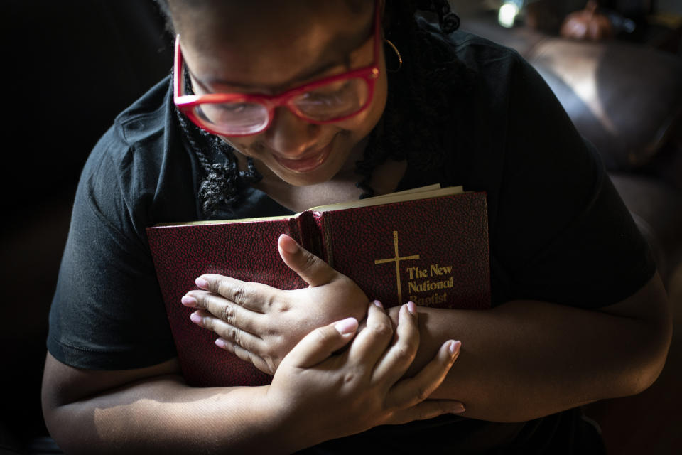 Jessica Guthrie breaks into tears as she is overwhelmed by emotions while singing her mother's favorite hymn, "Take My Hand, Precious Lord" from her mother's hymnal, in Fredericksburg, Va., on Tuesday, Sept. 20, 2022. (AP Photo/Wong Maye-E)