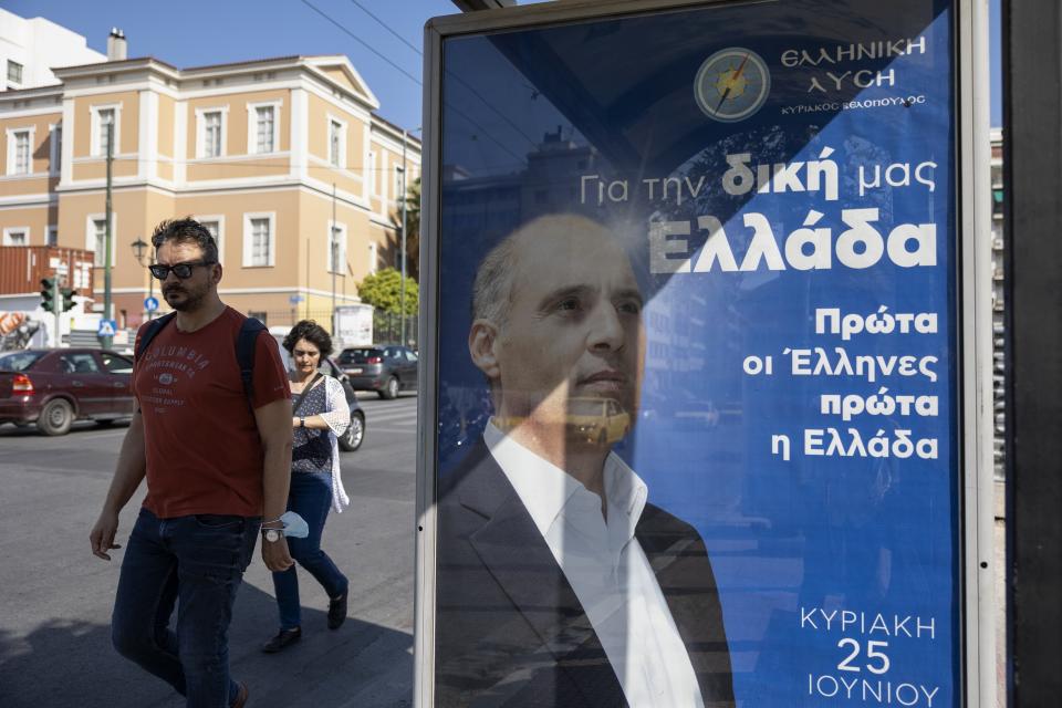 People walk past a bus stop with a poster of Kyriakos Velopoulos, Elliniki Lysi (Greek Solution), that reads "For our Greece, First the Greeks, First Greece" in Athens, Greece, Thursday, June 22, 2023. Three far-right and two far-left, could conceivably cross the 3% parliamentary entry threshold in Sunday's elections, despite a swing back to mainstream politicians as the scars of Greece's 10-year financial crisis gradually heal. (AP Photo/Yorgos Karahalis)