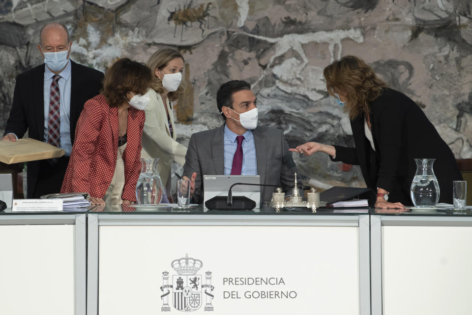 In this photo provided by the Spanish Government in Madrid, Spain's Prime Minister Pedro Sanchez, centre, speaks with three of his ministers, during a cabinet meeting at the Moncloa Palace in Madrid, Tuesday June 22, 2021. The Spanish Cabinet met on Tuesday to issue pardons for nine imprisoned Catalans who spearheaded the 2017 effort to set an independent republic in the affluent northeastern region, a move that Prime Minister Pedro Sanchez says is needed to bring reconciliation. (Borja Puig de la Bellacasa/Spanish Government via AP)