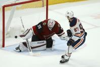 Edmonton Oilers center Connor McDavid (97) scores a goal against Arizona Coyotes goaltender Darcy Kuemper (35) during a shootout of an NHL hockey game Sunday, Nov. 24, 2019, in Glendale, Ariz. The Oilers defeated the Coyotes 4-3. (AP Photo/Ross D. Franklin)