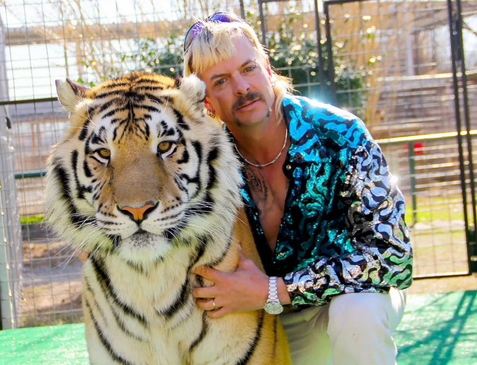 Joe Exotic, posing in an infamous photo with one of his tigers, asked Kim Kardashian for help getting out of prison on her sister Kourtney Kardashian Barker's baby photo.