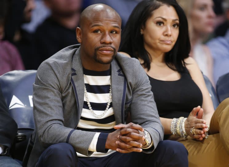 Boxer Floyd Mayweather Jr. and Jamie Lynn sit courtside as they attend the NBA basketball ball game between the Los Angeles Lakers and Washington Wizards. (AP Photo/Danny Moloshok)