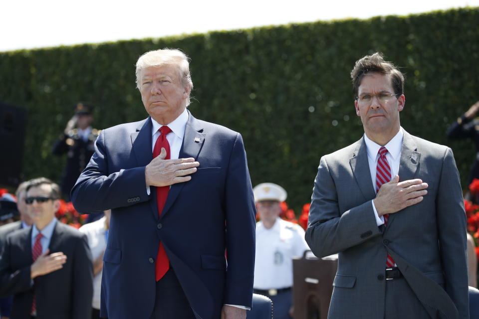 FILE - In this July 25, 2019, file photo, President Donald Trump and Secretary of Defense Mark Esper, right, stand during the playing of the National Anthem, during a ceremony for Esper, at the Pentagon. If there was one day that crystallized all the forces that led to the impeachment investigation of President Donald Trump, it was July 25. That was the day of his phone call with Ukraine’s new leader, pressing him for a political favor. (AP Photo/Alex Brandon, File)