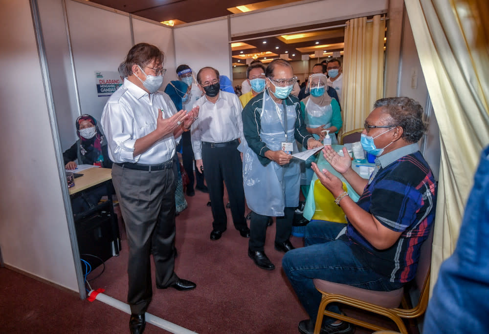 File picture shows Sarawak Chief Minister Datuk Patinggi Abang Johari Openg praying with a vaccine recipient at Universiti Malaysia Sarawak’s Covid-19 vaccination centre in Kuching, June 18, 2021. — Bernama pic