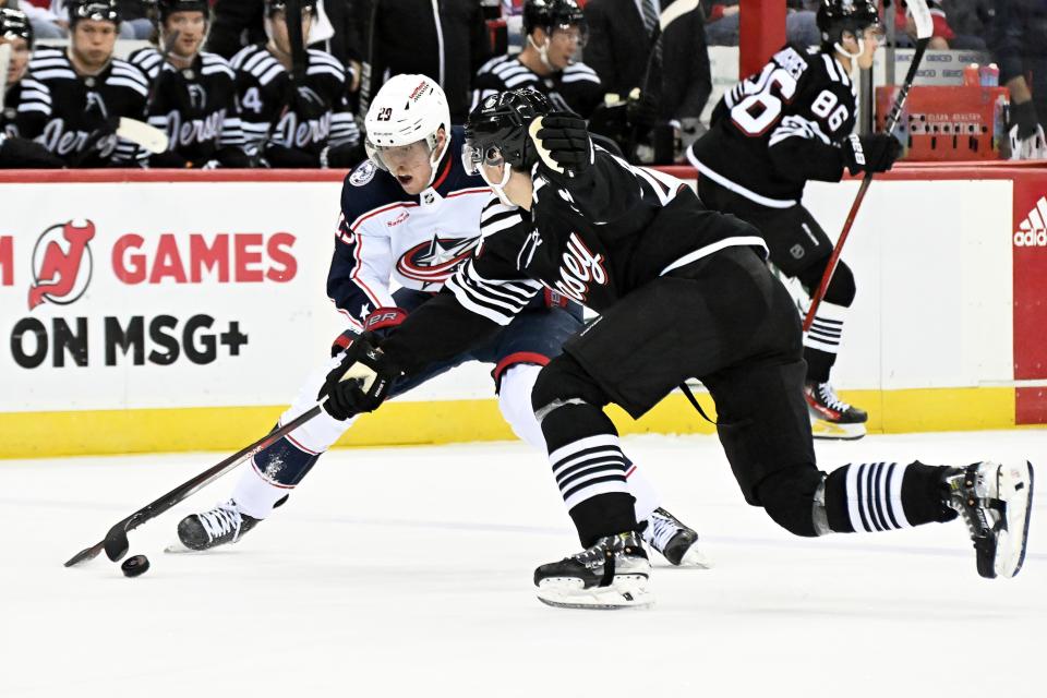 Columbus Blue Jackets right wing Patrik Laine (29) and New Jersey Devils defenseman Luke Hughes (43) battle for control of the puck during the first period of an NHL hockey game Friday, Nov. 24, 2023, in Newark, N.J. (AP Photo/Bill Kostroun)