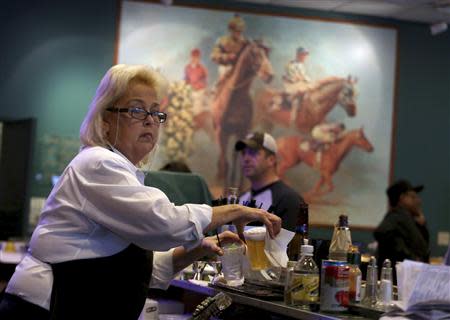 Bartender Nola Ferraro works at Betfair Hollywood Park, which is closing down at the conclusion of tomorrow's race card after operating for 75 years, in Inglewood, California December 21, 2013. REUTERS/Jonathan Alcorn