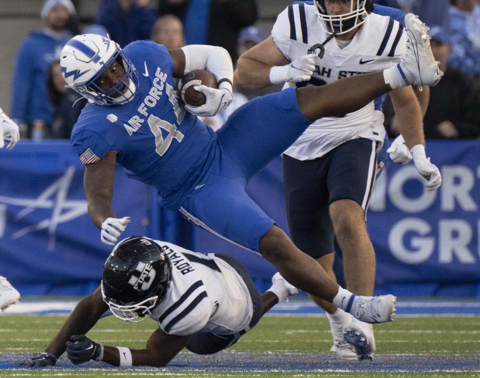 Air Force linebacker Johnathan Youngblood (44) is tackled by Utah State wide receiver Jalen Royals, bottom, after making an interception during the first half of an NCAA college football game in Air Force Academy, Colo., Friday, Sept. 15, 2023. | Christian Murdock/The Gazette via AP