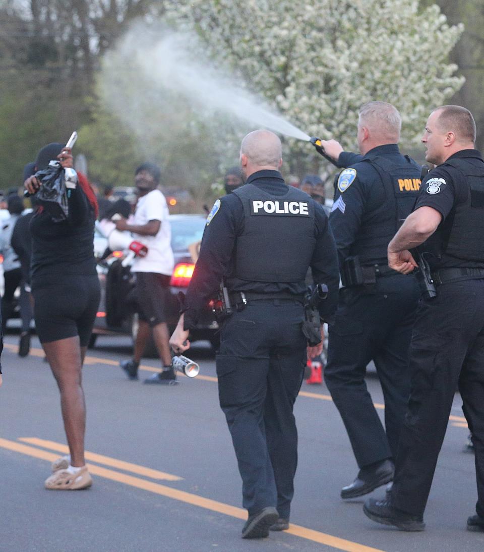 Akron police officers deploy a chemical spray Wednesday night to disperse protester blocking traffic on Copley Road.